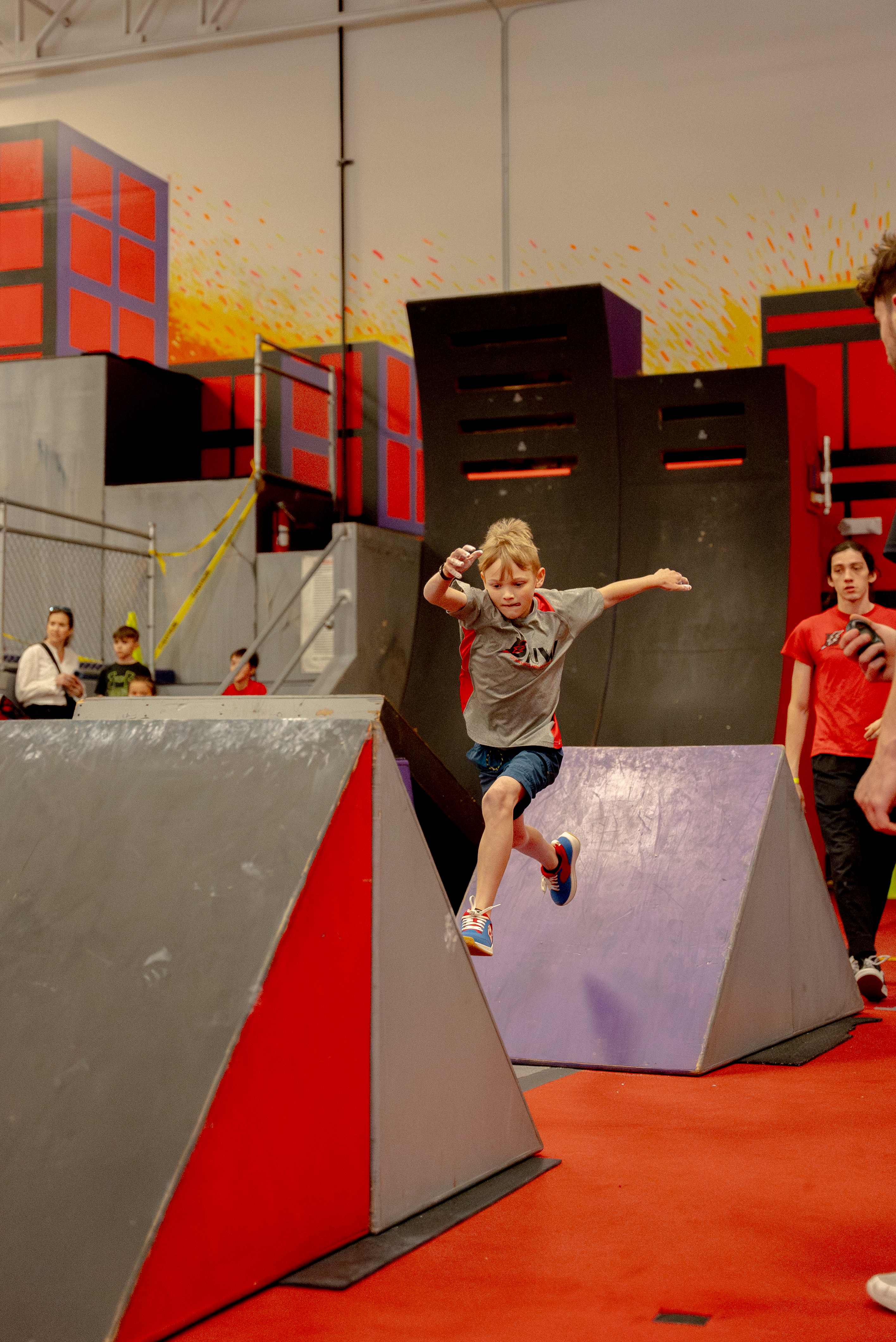 NES athlete jumping between angled ramps during competition